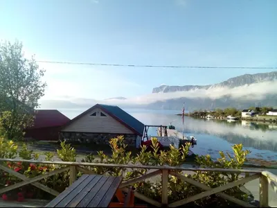 a house on the shore of a body of water at Gemütliche Ferienwohnung am Fjord