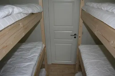 a room with two bunk beds and a door at Gemütliche Ferienwohnung am Fjord