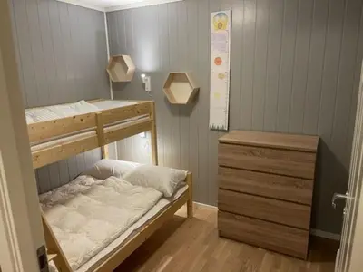 a bedroom with a bunk bed and a wooden dresser at Ferieleilighet i Tråstølen in Vossevangen