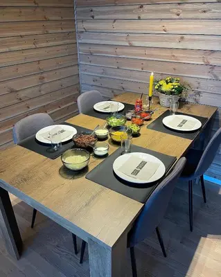 a wooden table with plates and bowls of food on it at Ferieleilighet i Tråstølen in Vossevangen