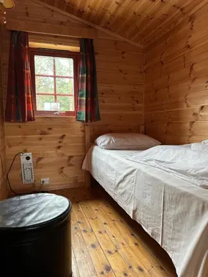 a bedroom with a bed in a log cabin at Bjorliheimen Fjellhotell-Hytte 9 in Bjorli