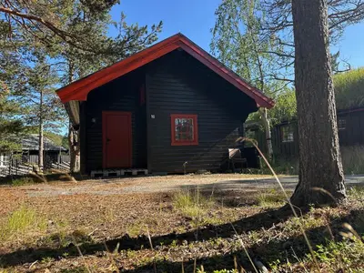 a small cabin with a red door and a tree at Bjorliheimen Fjellhotell-Hytte 10 & 17 in Bjorli