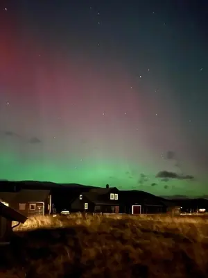 an aurora in the sky over a house at Modern cabin sauna, BBQ & beautiful view Filefjell in Tyinkrysset