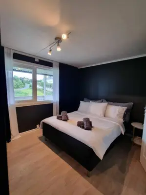 a bedroom with a large bed with two teddy bears on it at Nyoppusset leilighet nær Aker og sentrum in Stord