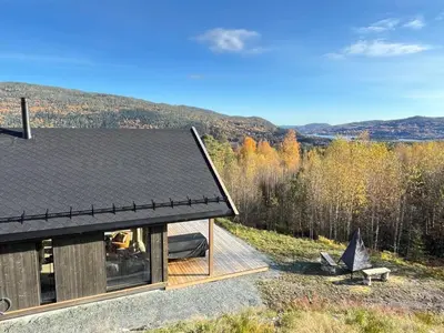 a house with a black roof on a hill at Spacious lodge with sauna, ski centre in Noresund