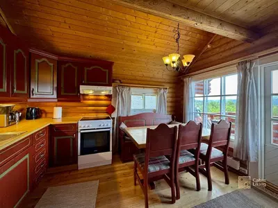 a kitchen and dining room with a table and chairs at Beitostølen Cabin - Sauna, large terrace and BBQ in Beitostøl