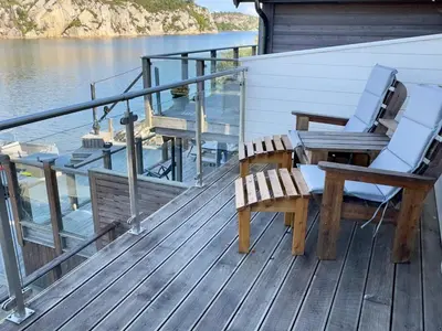 a deck with two chairs and a table on a boat at 8 person holiday home in Urangsvåg in Ervik