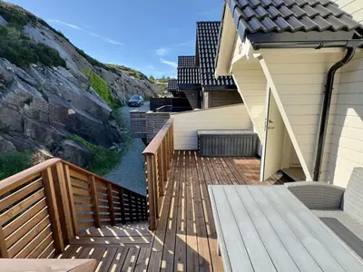 a wooden deck with stairs next to a house at 8 person holiday home in Urangsvåg in Ervik
