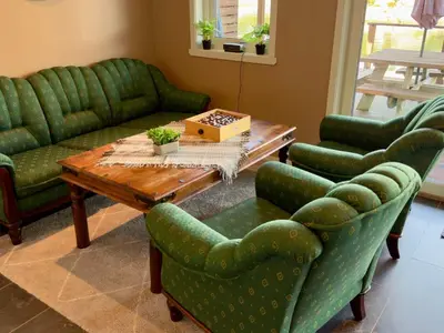 a living room with green couches and a table and chairs at 8 person holiday home in Urangsvåg in Ervik