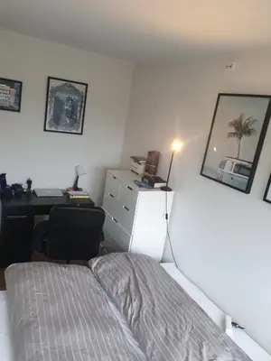a bedroom with a bed and a desk and a desk at Modern apartment in Trondheim