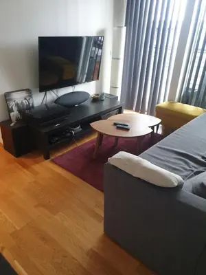 a living room with a bed and a tv and a table at Modern apartment in Trondheim