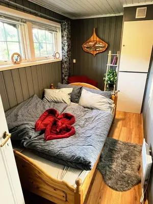 a bed with a red blanket on it in a room at Lykke House Hot Tub, Grill Hut Northern Lights in Trysil