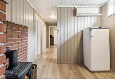a kitchen with a refrigerator and a brick wall at Lykke House Hot Tub, Grill Hut Northern Lights in Trysil