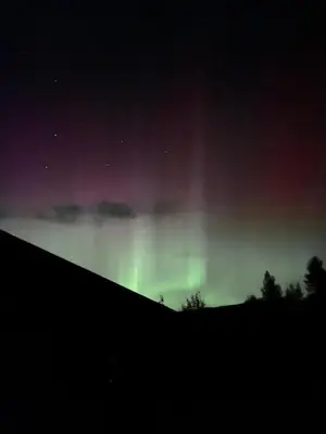 an aurora dances in the sky at night at Lykke House Hot Tub, Grill Hut Northern Lights in Trysil