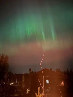 an aurora in the sky above a house at Lykke House Hot Tub, Grill Hut Northern Lights in Trysil