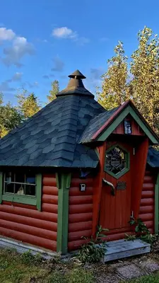 a small red cabin with a black roof at Lykke House Hot Tub, Grill Hut Northern Lights in Trysil