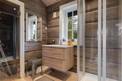 a bathroom with wooden walls and a sink and a shower at Trysilfjell 811 by Vacation Trysil in Trysil