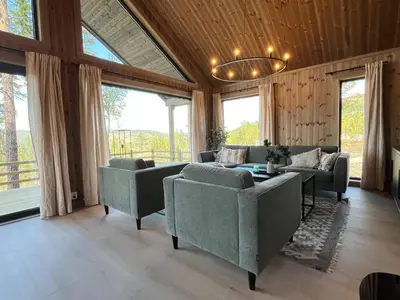 a living room with couches and a chandelier at Skogsbu - Stylish, Close to Ski centers and hiking trails in Nesbyen