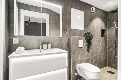 a bathroom with a white sink and a toilet at Light & Modern, City Apartment in Bergen