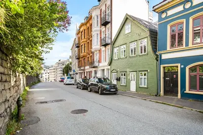 a street with colorful houses and cars parked on the street at Light & Modern, City Apartment in Bergen