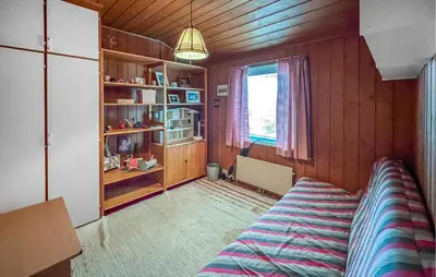 a bedroom with a bed and wooden walls and a window at Lovely Home In Hamar With Wifi in Hamar