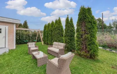 a yard with wicker chairs and chairs and trees at Lovely Home In Hamar With Wifi in Hamar
