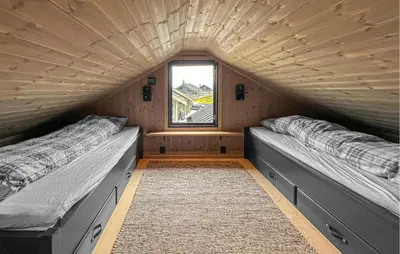 two beds in a small room with a window at Cozy Home In Svingvoll With House A Mountain View in Svingvoll