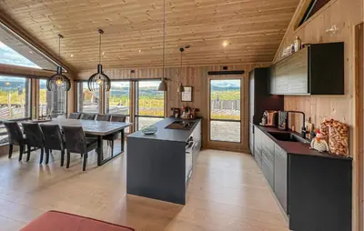 a kitchen and dining room with a table and chairs at Cozy Home In Svingvoll With House A Mountain View in Svingvoll