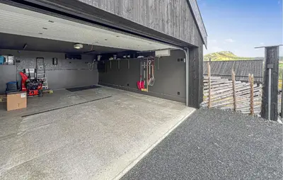 a garage with a garage door open on a building at Cozy Home In Svingvoll With House A Mountain View in Svingvoll