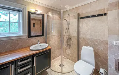 a bathroom with a shower and a toilet and a sink at Nice Home In Lillehammer in Lillehammer