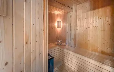a wooden sauna with a light on the wall at Nice Home In Lillehammer in Lillehammer