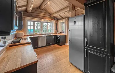 a kitchen with a stainless steel refrigerator and wooden floors at Nice Home In Lillehammer in Lillehammer
