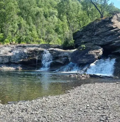 a waterfall on the side of a river at Luxury Mountain Cabin with Hot Tub and Views in Budal in Storen