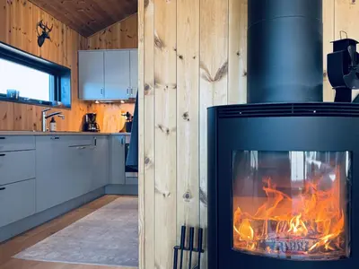 a fireplace in a kitchen with a fire in it at Moderne leilighet i Vestlia-Ski in ski out in Geilo