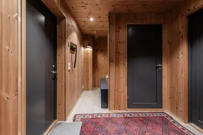 a hallway with wooden walls and a large black door at Moderne leilighet i Vestlia-Ski in ski out in Geilo
