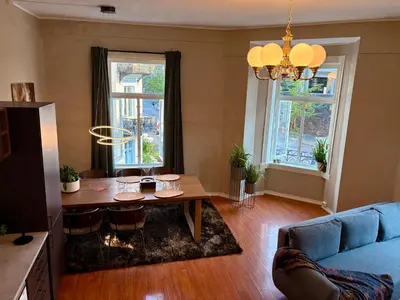 a living room with a table and a blue couch at Charming apartment Nygårdsparken in Bergen