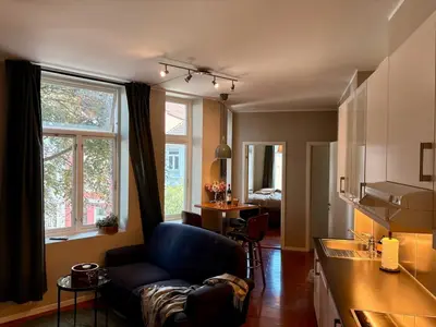 a living room with a couch and a kitchen at Apartment in apartment building, close to the train station in Bergen