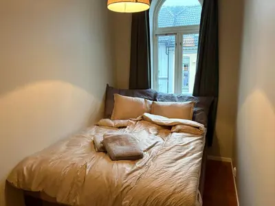 a bed with two towels on it in a bedroom at Apartment in apartment building, close to the train station in Bergen