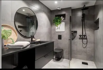 a bathroom with a sink and a shower with a mirror at Spectacular view 2 roms apartment in Bergen