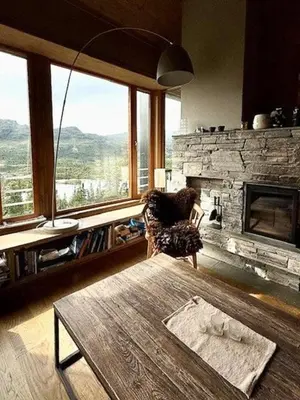 a living room with a table and a fireplace at Lodge With Views Of Gaustatoppen Mountain in Rjukan