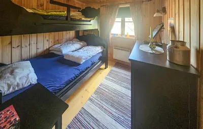 a bedroom with a bed and a desk in a room at 4 Bedroom Stunning Home In Tuddal in Tuddal