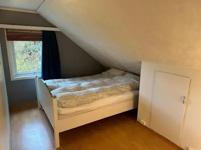 a bed in a small room with a window at Sauda 4 bedrooms near skiing with view of fjord in Sauda