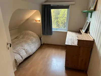 a bedroom with a bed and a desk and a window at Sauda 4 bedrooms near skiing with view of fjord in Sauda