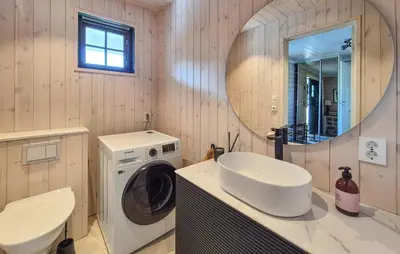 a bathroom with a sink and a washing machine at Stunning Home In Vikebygd With House A Mountain View in Vikebygd