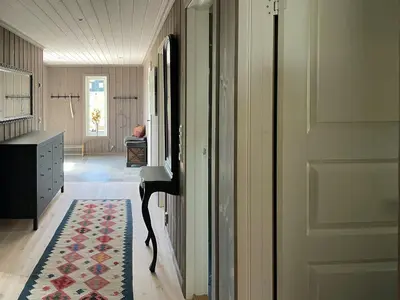a hallway with a door and a rug on the floor at Cabin With Panoramic Views Over The Mountains in Nesbyen