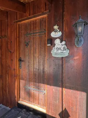 a wooden wall with a door and a lamp at Tvilsombu, cosy cabin close to ski slopes in Geilo