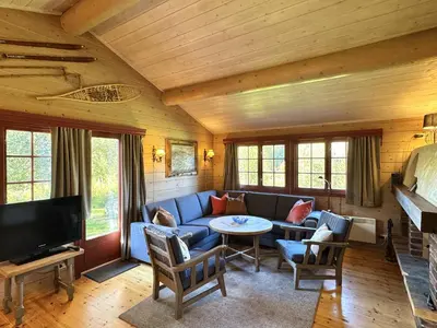 a living room with a blue couch and a tv at Tvilsombu, cosy cabin close to ski slopes in Geilo