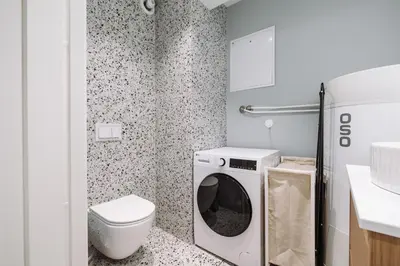 a bathroom with a washer and dryer in it at Large city apartment with sea view and parking in Ålesund