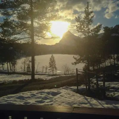 a view of a mountain in the snow with the sun at Renovated Cabin By Lake Djupedal in Bygstad