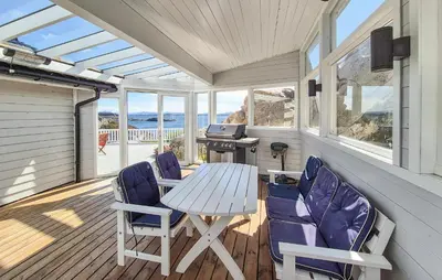 a screened in porch with a table and chairs at 4 Bedroom Gorgeous Home In Steinsland in Steinsland